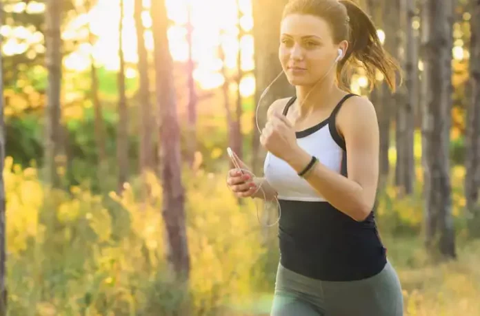 Eiweiß - Diät - Ein Frau joggt im Wald mit Sonnenschein.