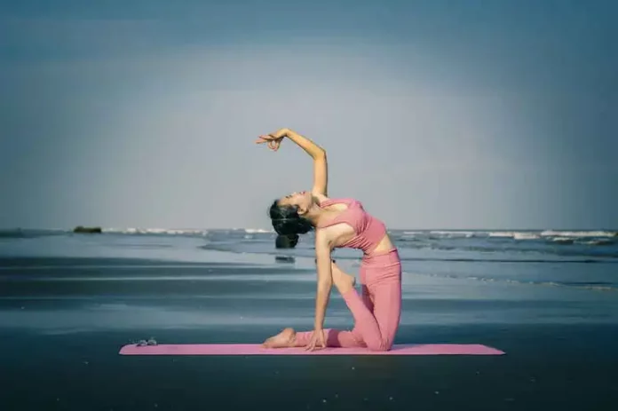 Yoga für Einsteiger - Eine Frau am Meer betreibt Yoga